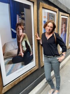 Eva Sifis standing in front of her photo in the Home exhibition, Melbourne